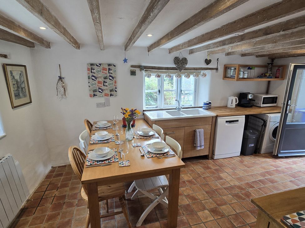 A kitchen with a dining table and kitchen appliances at Picket Mead Southleigh near Colyton