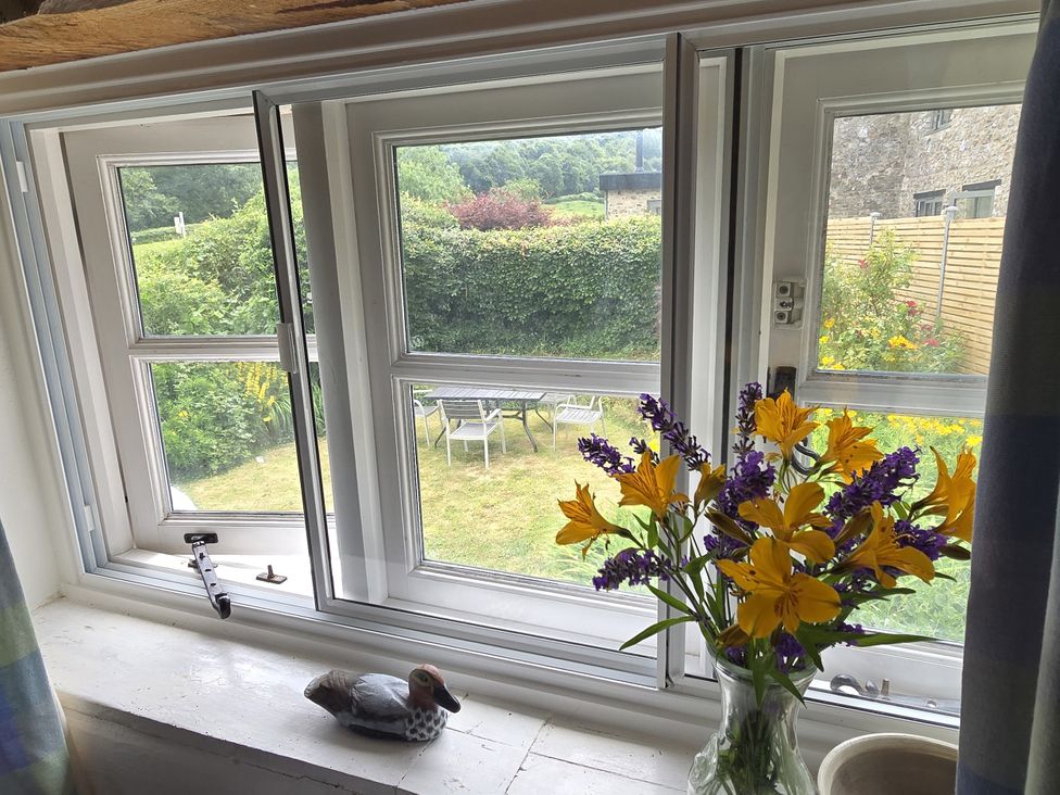 A window with flowers and a garden view at Picket Mead Southleigh near Colyton