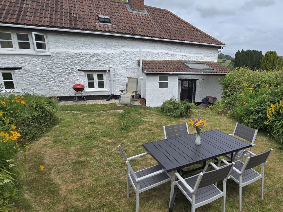 A garden with a table and chairs at Picket Mead Southleigh near Colyton