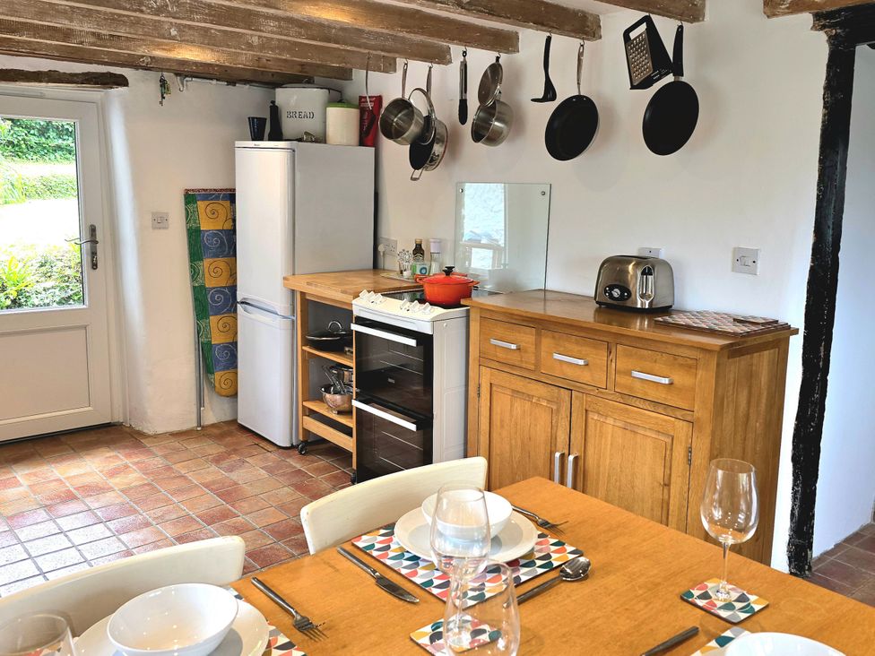 A kitchen with appliances and dining table at Picket Mead Southleigh near Colyton
