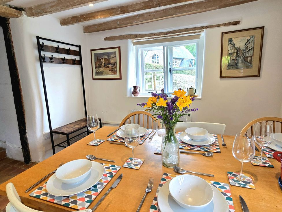 A dining room with a table set for a meal at Picket Mead in Southleigh near Colyton