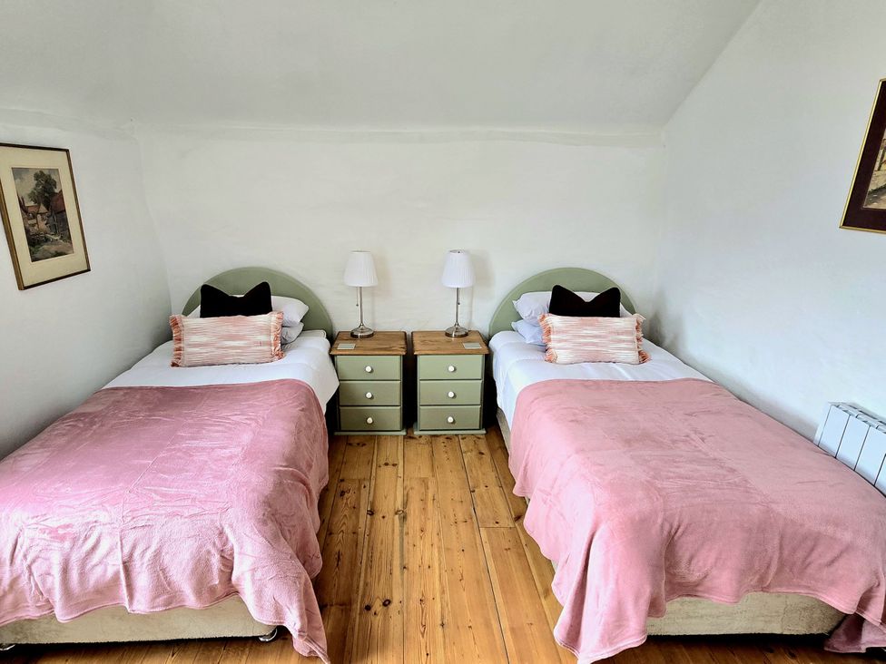 A bedroom with two beds and a nightstand at Picket Mead Southleigh near Colyton