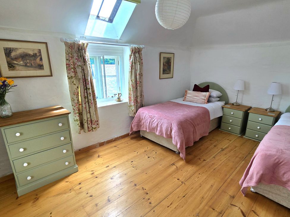 A bedroom with two beds and a window at Picket Mead Southleigh near Colyton