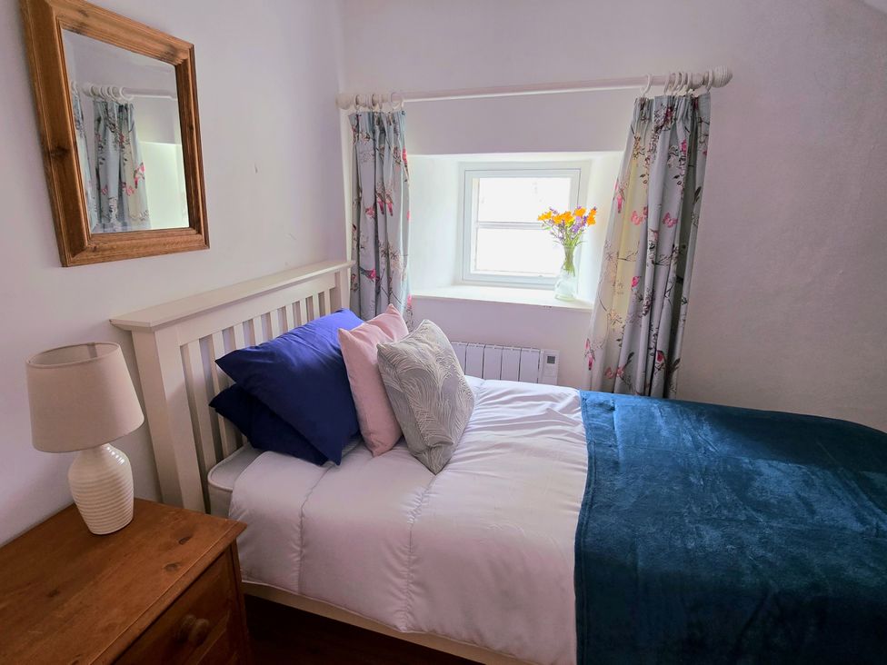 A bedroom with a bed and a vase of flowers at Picket Mead Southleigh near Colyton