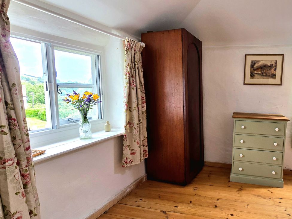 A bedroom with a window, cabinet, and chest of drawers at Picket Mead in Southleigh near Colyton