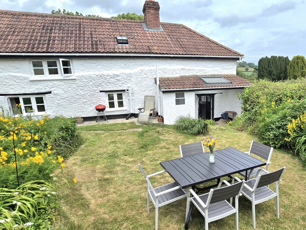 A garden with a table and chairs at Picket Mead Southleigh near Colyton
