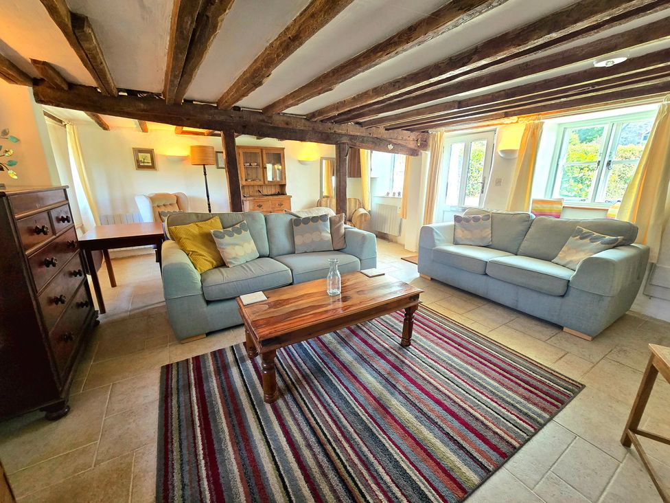 A living room with sofas and a wooden table at Picket Mead Southleigh near Colyton