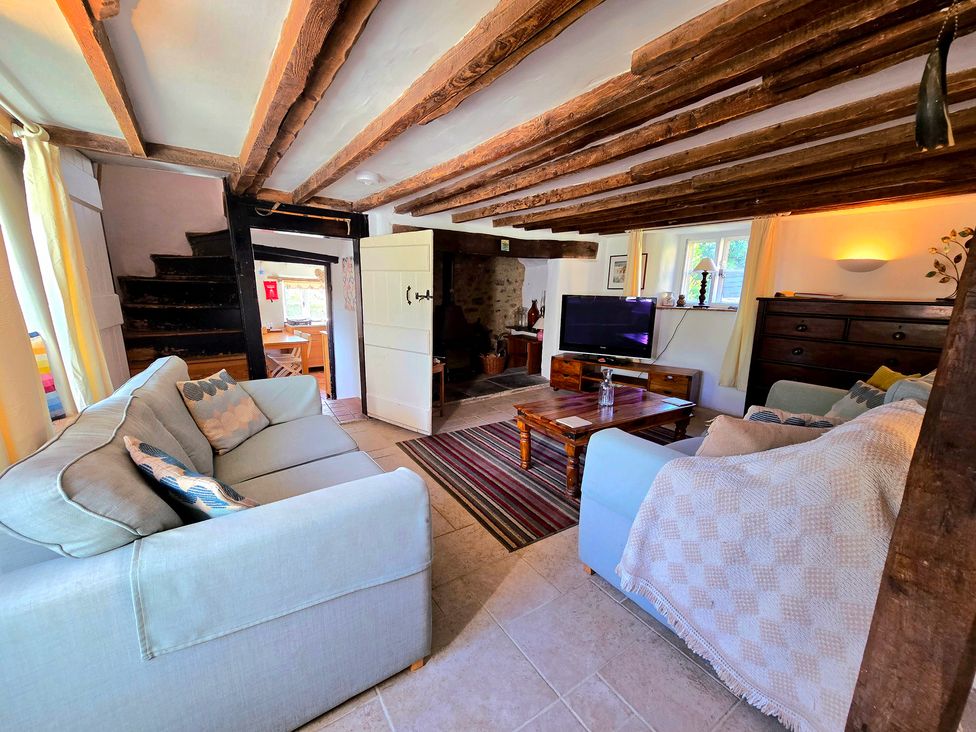 A living room with a sofa, coffee table, and television at Picket Mead in Southleigh near Colyton