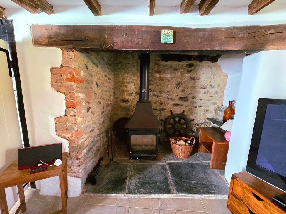 A living room with wood stove and stone wall at Picket Mead Southleigh near Colyton