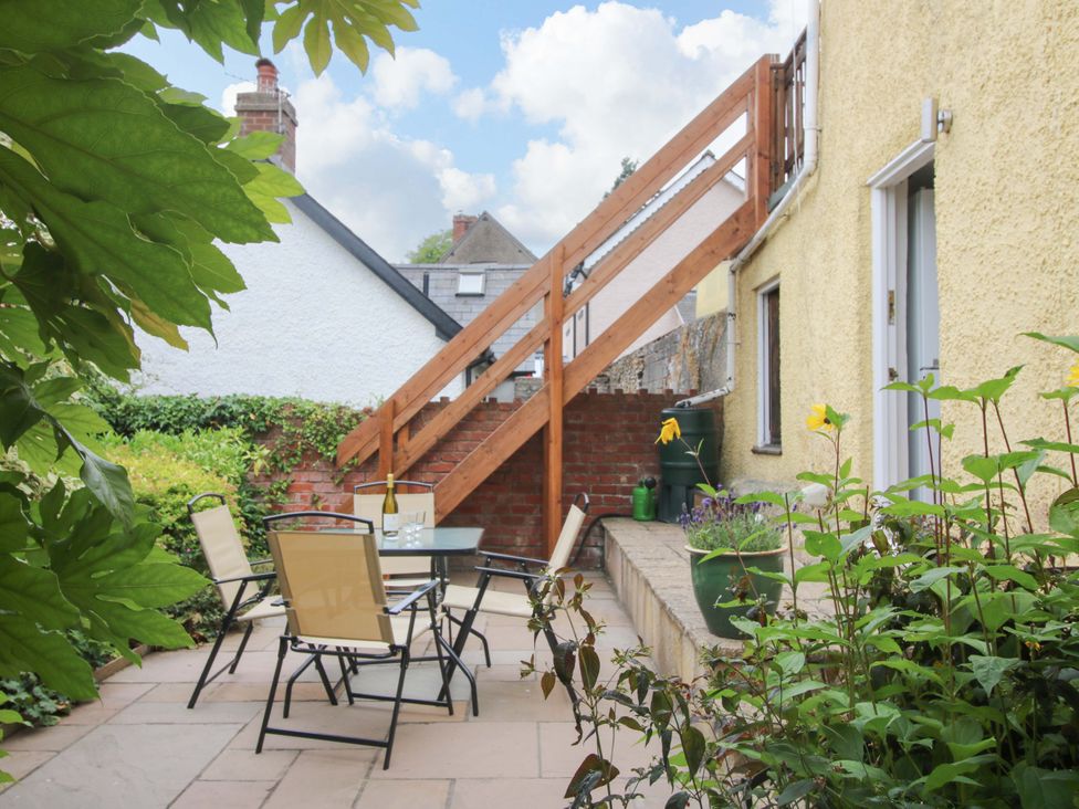 A garden with a table and chairs near a staircase at 41 High Street in Bishop's Castle