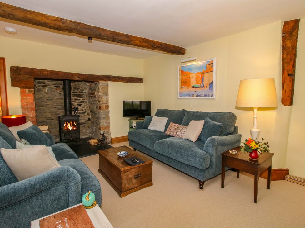 A living room with a fireplace and television at 41 High Street in Bishop's Castle