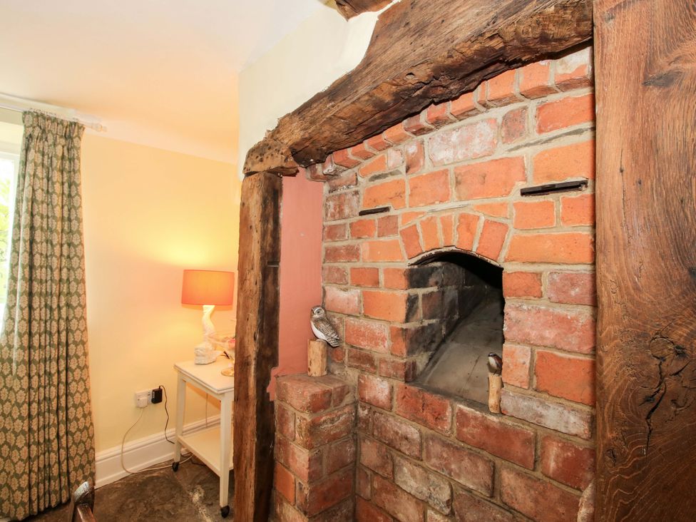 A snug with a brick fireplace and a wooden beam at 41 High Street, Bishop's Castle