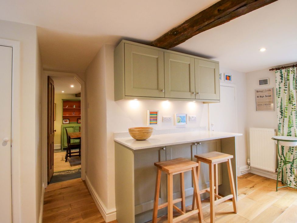 A kitchen with bar stools and cabinets at 41 High Street in Bishop's Castle