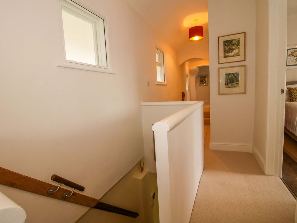 A hallway with staircase and wall art at 41 High Street, Bishop's Castle