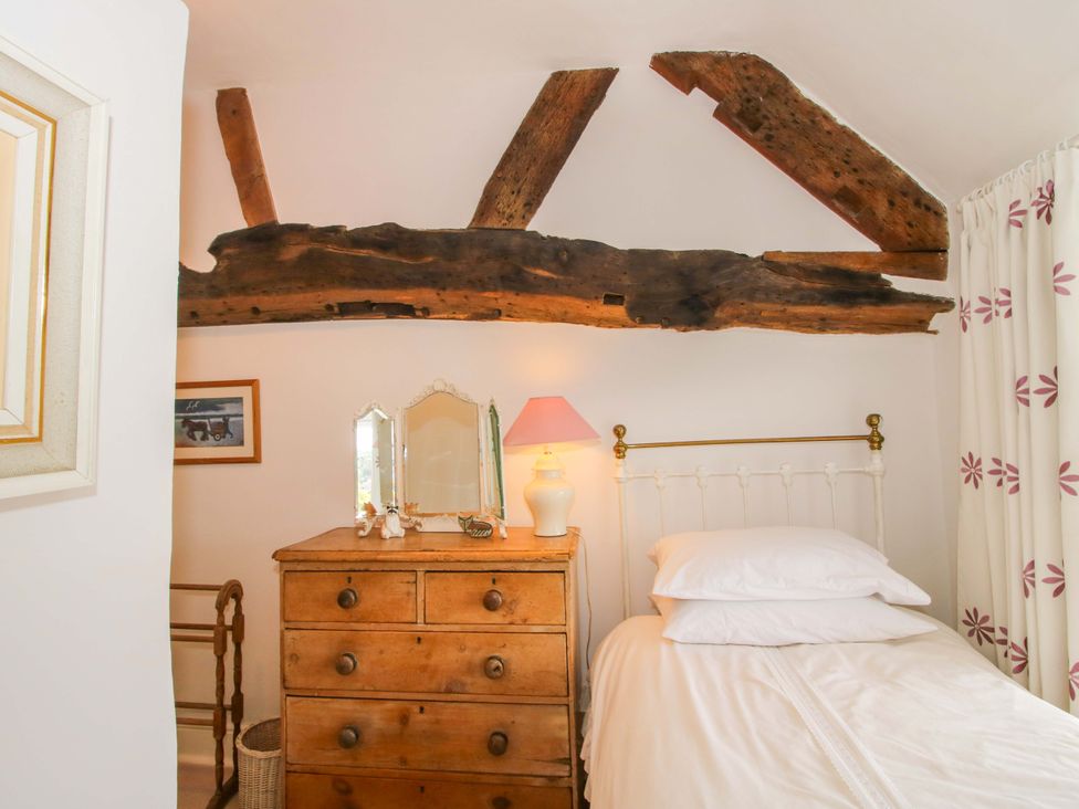 A bedroom with a bed, chest of drawers, and a lamp at 41 High Street, Bishop's Castle