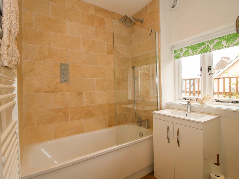 A bathroom with a bathtub, sink, and shower at 41 High Street Bishop's Castle