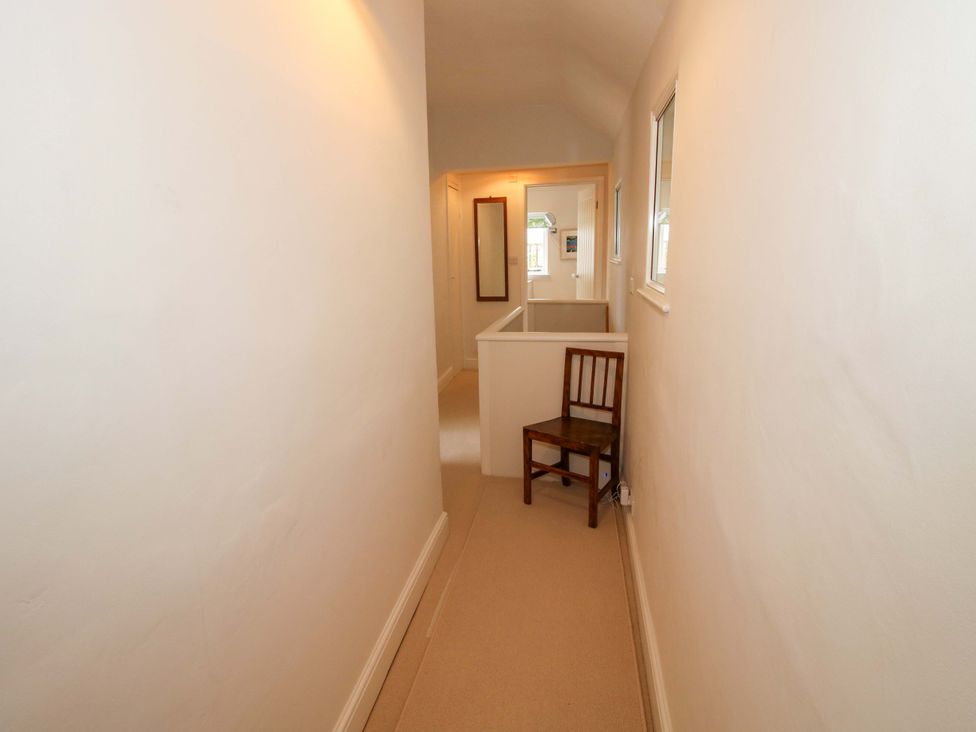 A hallway with a chair and a mirror at 41 High Street, Bishop's Castle
