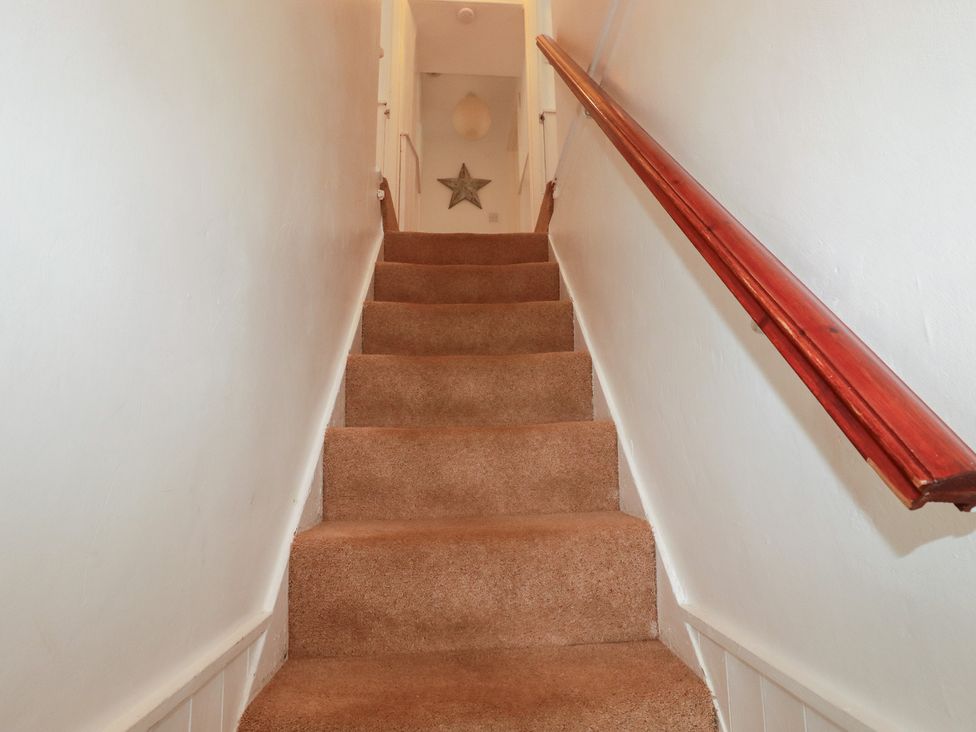 A staircase with carpet and a handrail at Nanvivian in Feock near Truro