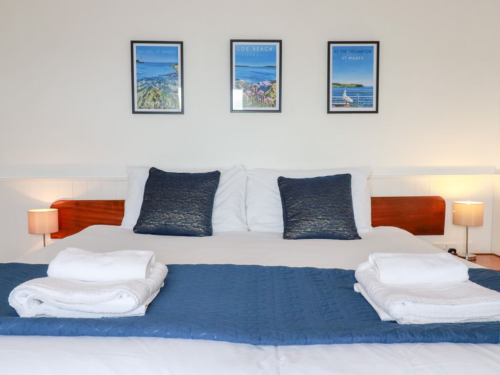 A bed with pillows and artwork on the wall at Nanvivian Feock near Truro