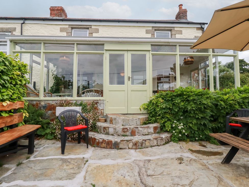A conservatory with steps and seating area at Nanvivian in Feock near Truro