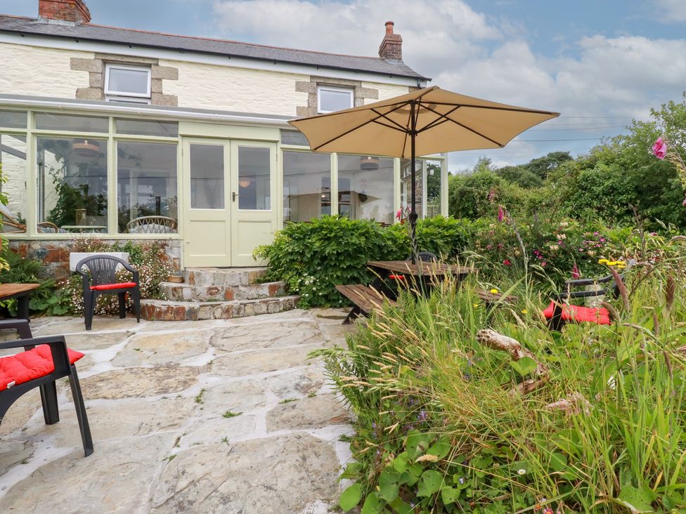 A garden with patio furniture and an umbrella at Nanvivian Feock near Truro