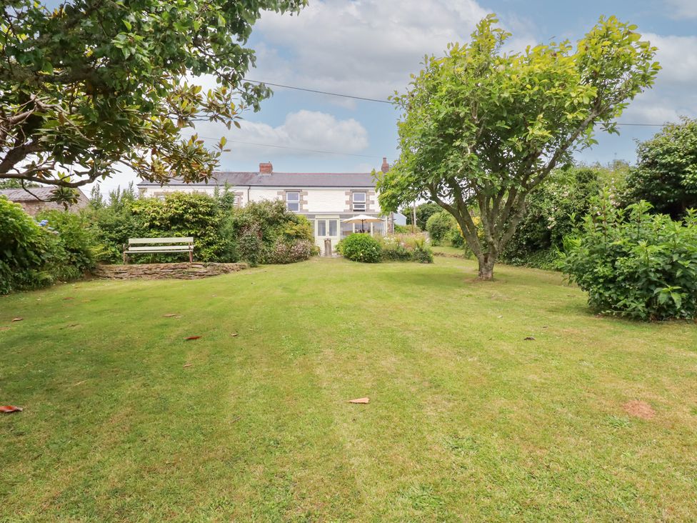 A garden with a house and trees at Nanvivian in Feock near Truro