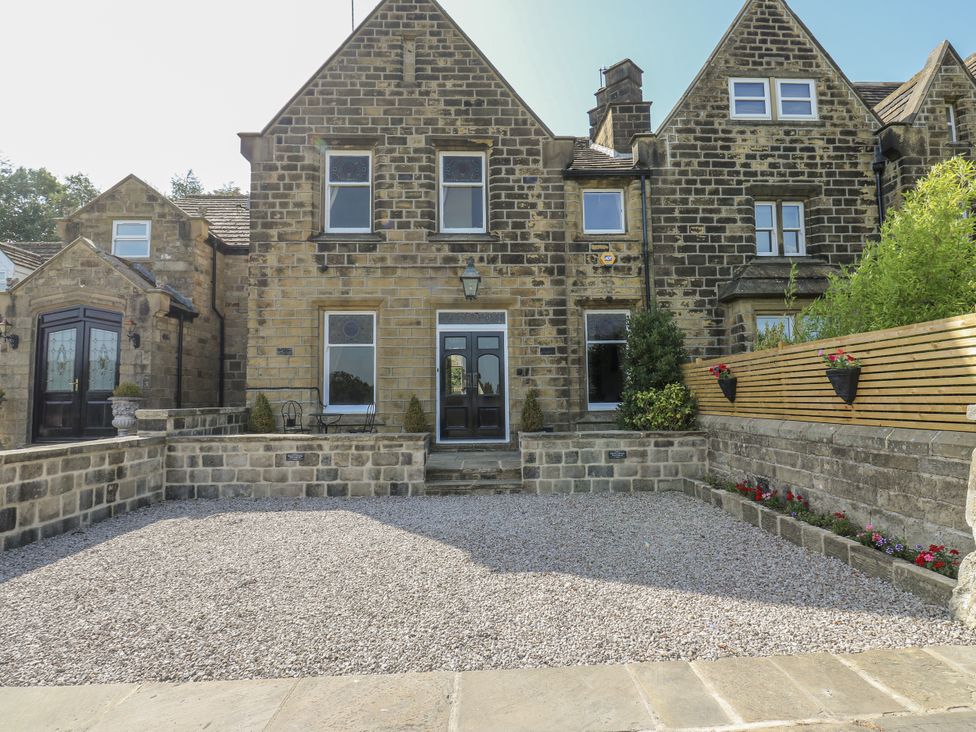 A stone house with a gravel driveway at Cold Spring House in Cullingworth