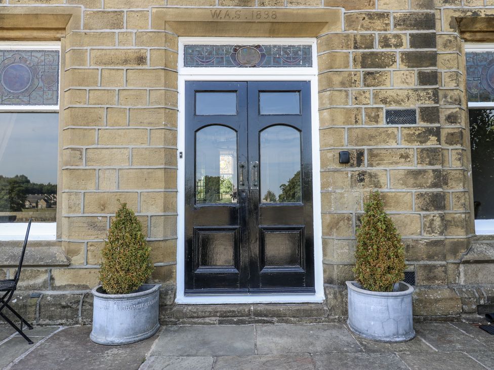 A front door with stained glass and plants at Cold Spring House in Cullingworth