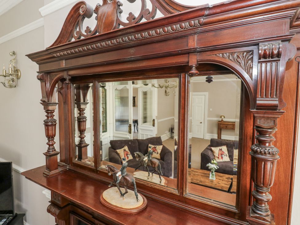 A living room with a mirror and horse figurine at Cold Spring House in Cullingworth