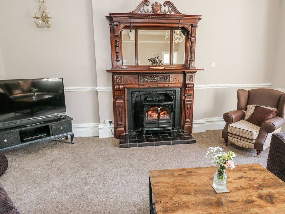 A living room with a fireplace and television at Cold Spring House in Cullingworth