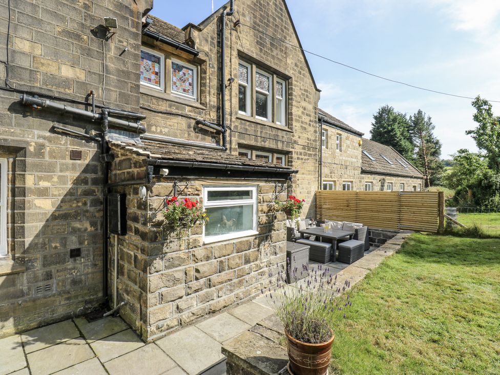 A garden with stone walls and outdoor furniture at Cold Spring House in Cullingworth