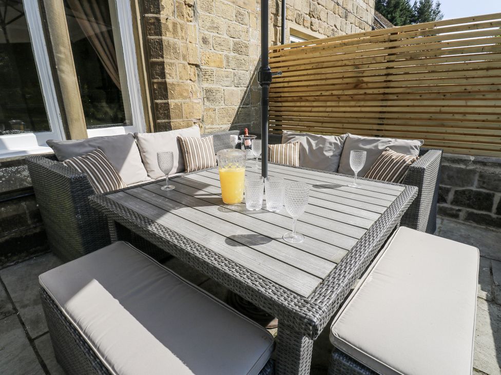An outdoor seating area with a table and chairs at Cold Spring House in Cullingworth