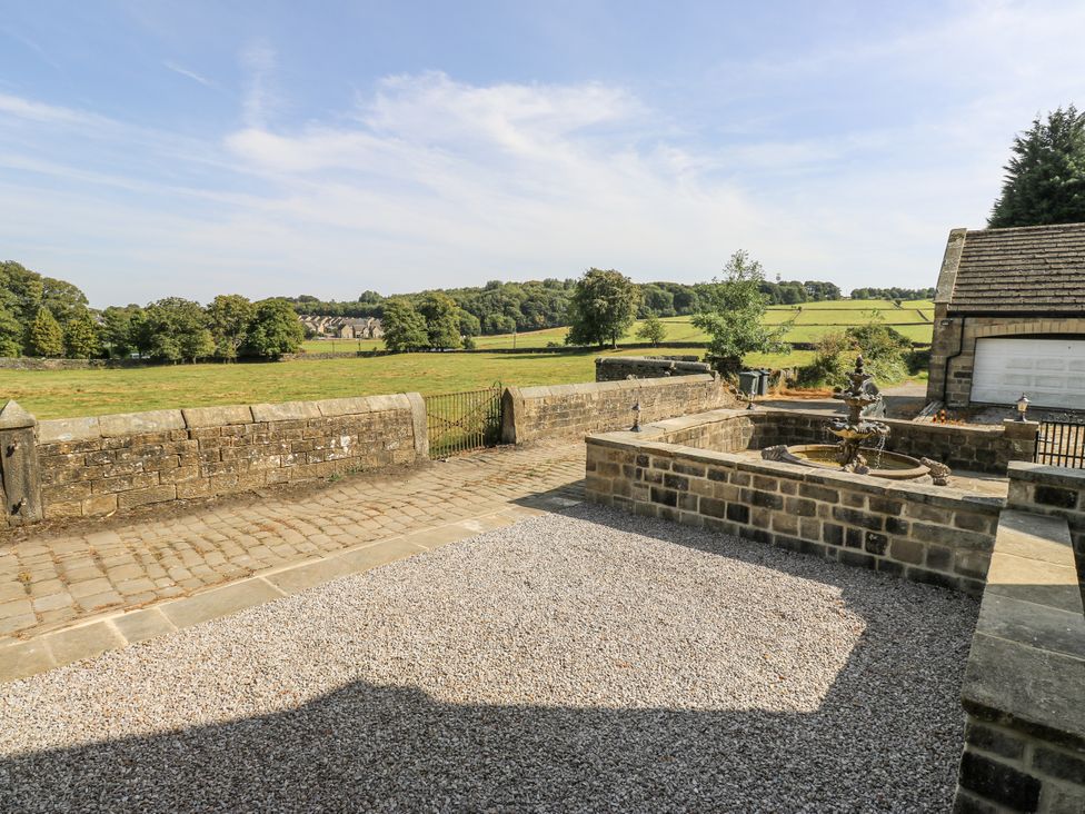 A garden with a stone fountain and gravel at Cold Spring House in Cullingworth