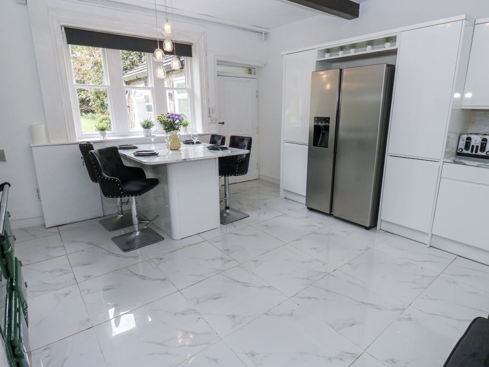A kitchen with a table and chairs at Cold Spring House in Cullingworth
