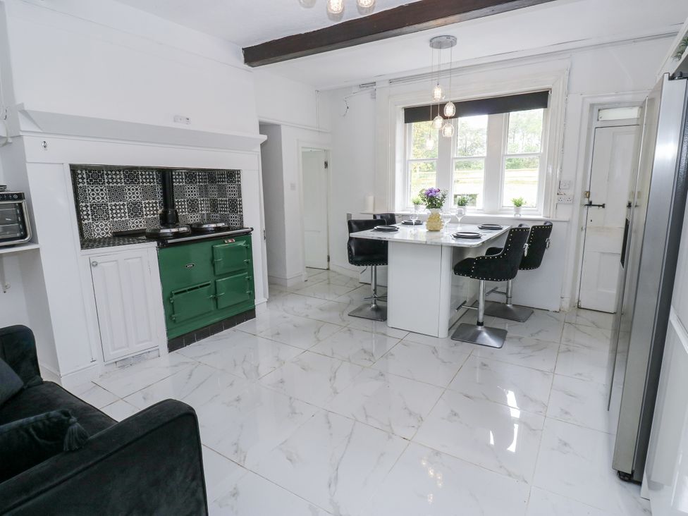 A kitchen with a cooking stove and dining table at Cold Spring House in Cullingworth