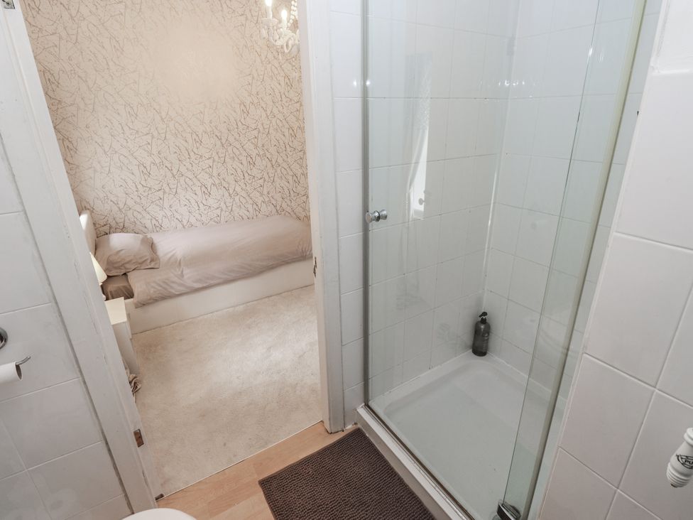 A bathroom with a shower and a bed visible at Cold Spring House in Cullingworth