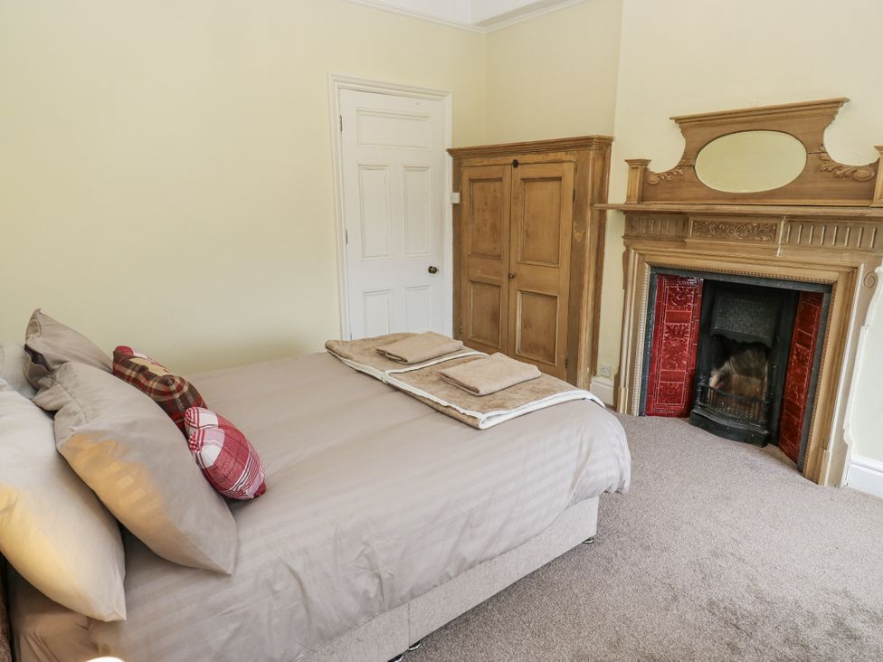 A bedroom with a bed and fireplace at Cold Spring House in Cullingworth