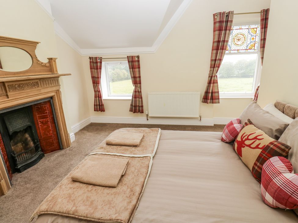 A bedroom with a bed and fireplace at Cold Spring House in Cullingworth