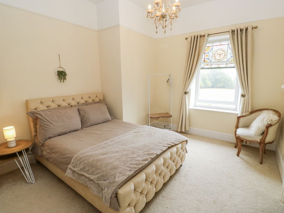 A bedroom with a bed, lamp, and window at Cold Spring House in Cullingworth