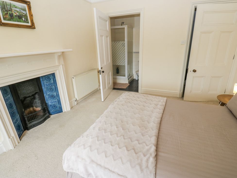 A bedroom with a bed and fireplace at Cold Spring House in Cullingworth