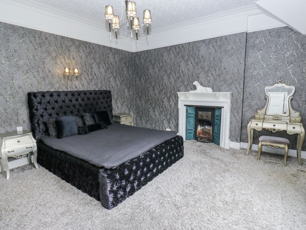 A bedroom with a bed and decorative fireplace at Cold Spring House in Cullingworth