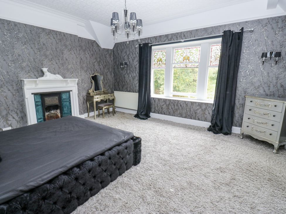 A bedroom with a bed and fireplace at Cold Spring House in Cullingworth