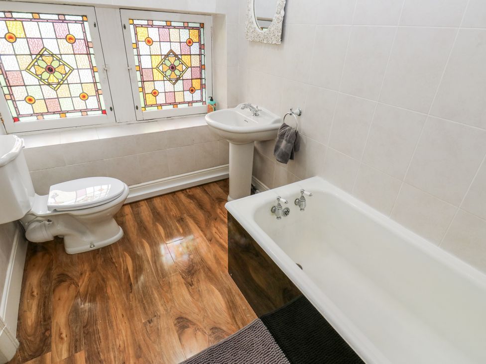 A bathroom with a bathtub, toilet, and sink at Cold Spring House in Cullingworth