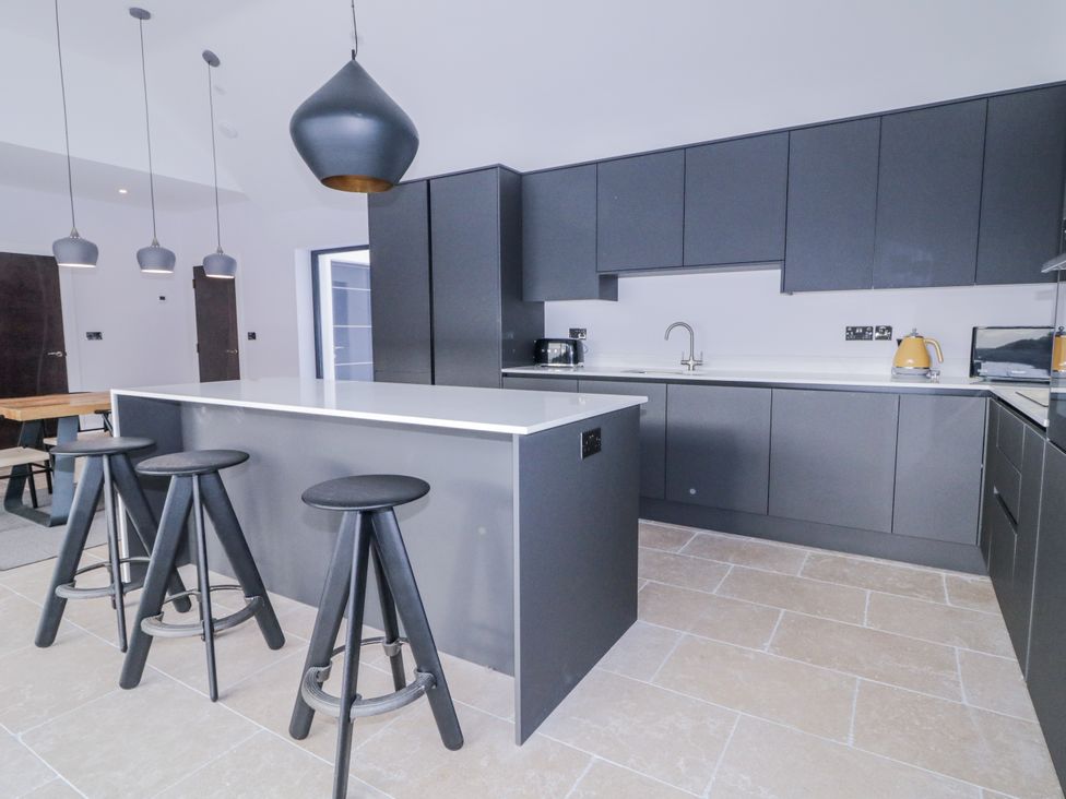 A kitchen with a kitchen island and bar stools at Cloneytrace Mines 
