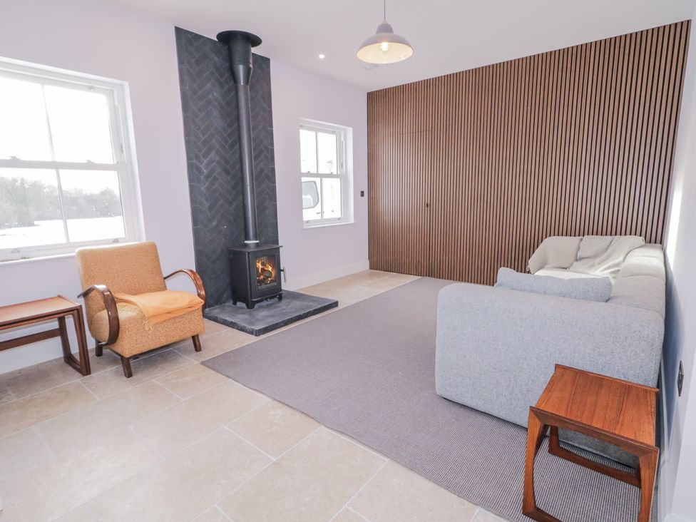 A living room with a fireplace and seating at Cloneytrace Mines 