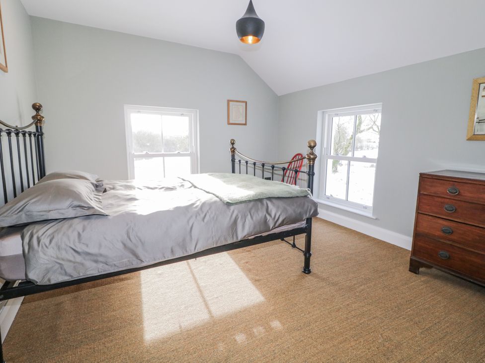 A bedroom with a bed and windows at Cloneytrace Mines