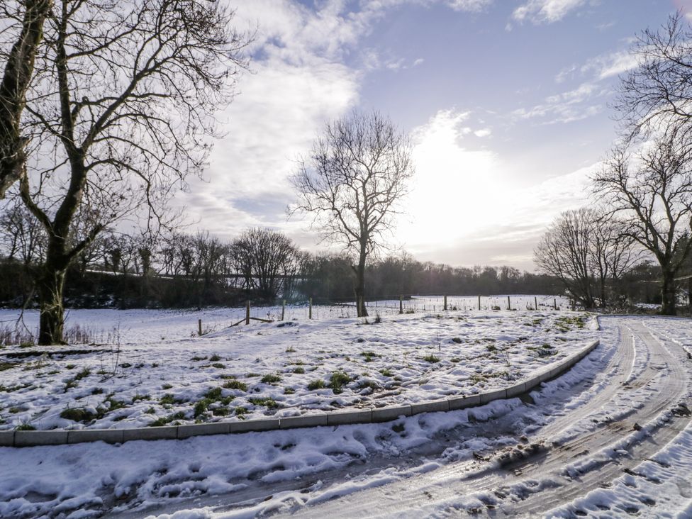 A snowy field with trees and a path at Cloneytrace Mines