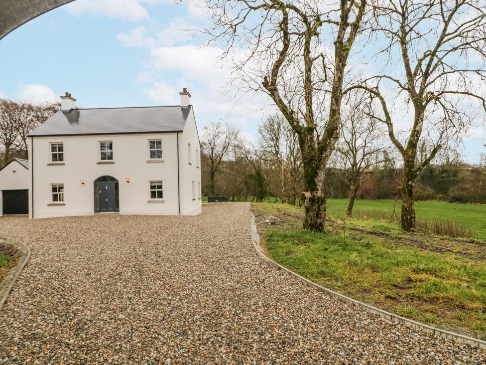 A house with a garage and a gravel driveway at Cloneytrace Mines in Broughshane