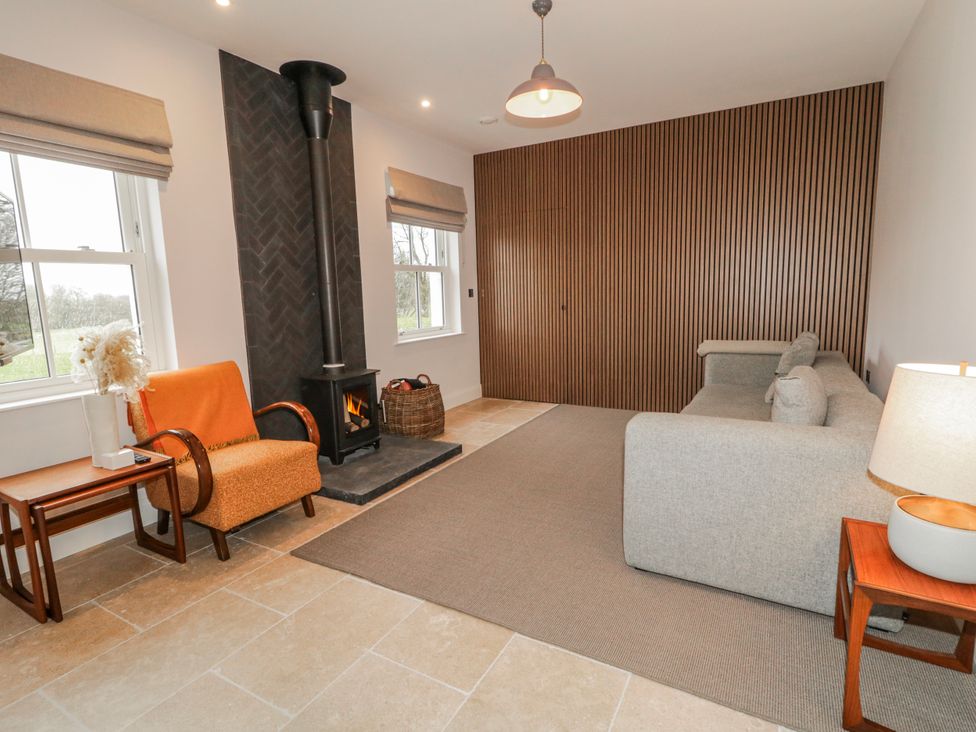 A living room with a sofa and stove at Cloneytrace Mines in Broughshane