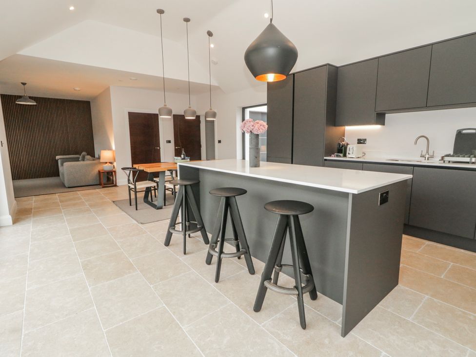 A kitchen with an island and stools at Cloneytrace Mines Broughshane